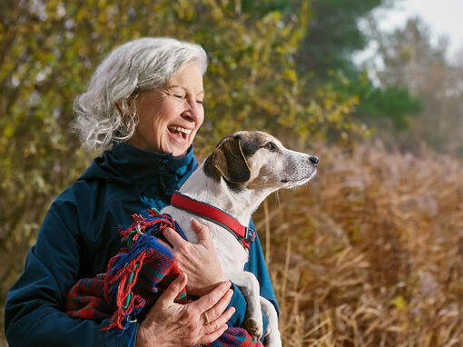 Vrouw met hond in een deken buiten